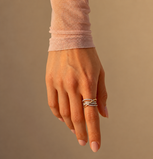 Milk & Rose Madonna Ring worn on a hand, showing the crossing two-tone bands and rows of clear stones.
