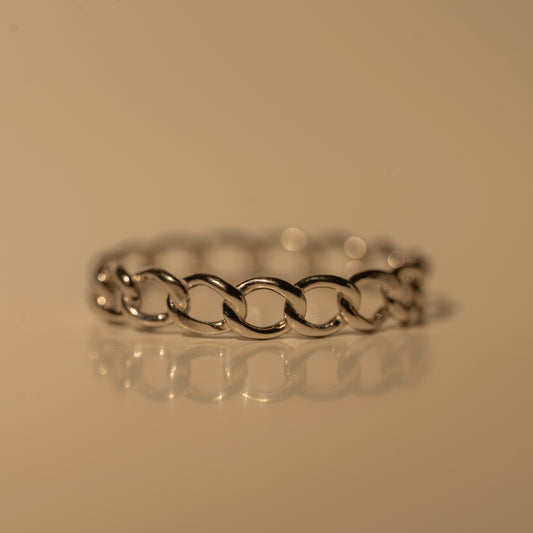 Milk & Rose Dainty Chain Ring in a silver tone, with polished oval links, shown resting flat on a reflective surface.