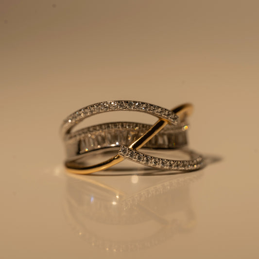 Front view of Milk & Rose Madonna Ring, with crossing gold-tone and silver-tone bands, rows of clear stones and a central baguette-style row.