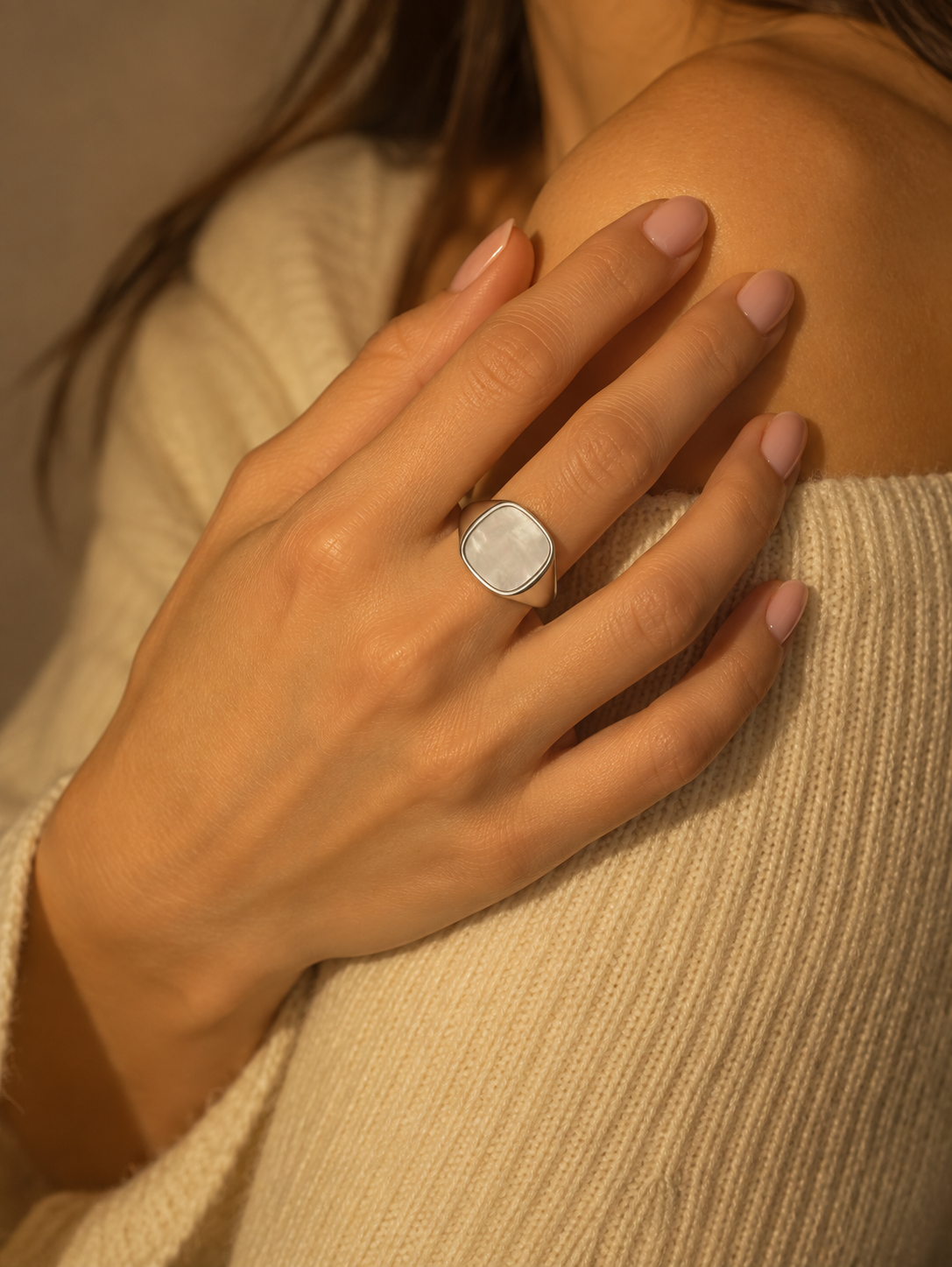 Close view of the Milk & Rose Kare Pearl Ring worn against a cream knit sweater, with a pale pearly panel in a polished silver-tone setting.