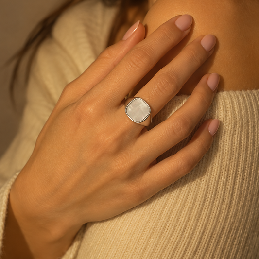 Close view of the Milk & Rose Kare Pearl Ring worn against a cream knit sweater, with a pale pearly panel in a polished silver-tone setting.
