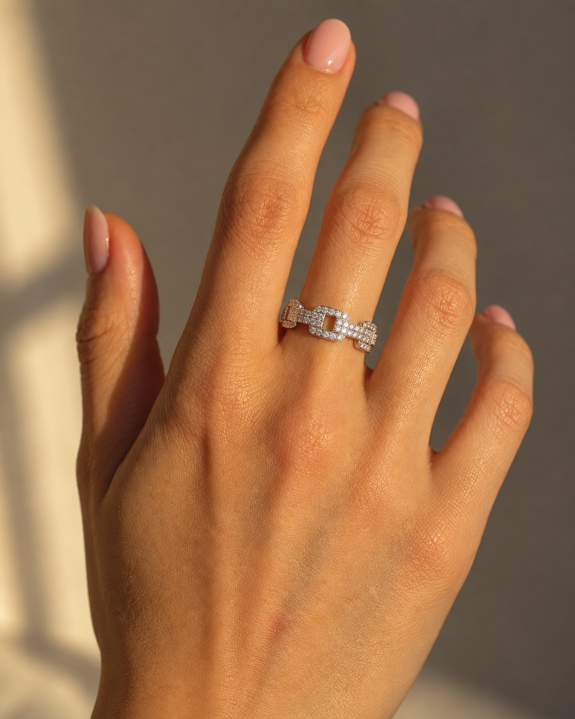 Milk & Rose Bold Chain Ring worn on a hand in sunlight, showing its open rectangular links and clear stones.